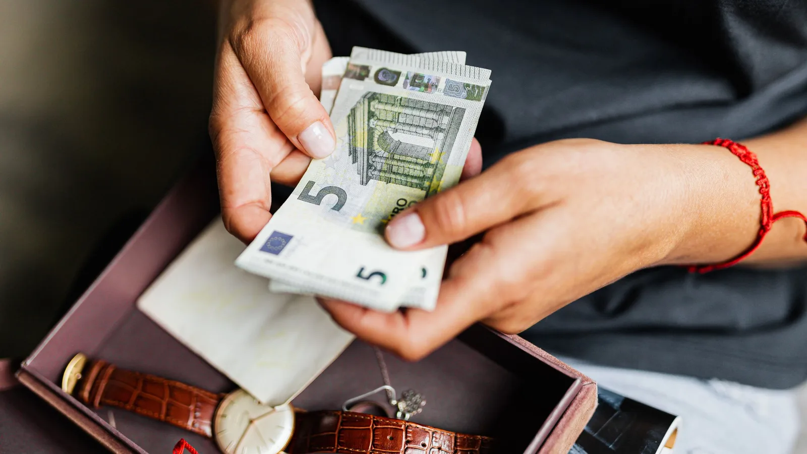 Manos contando billetes de euro en casa