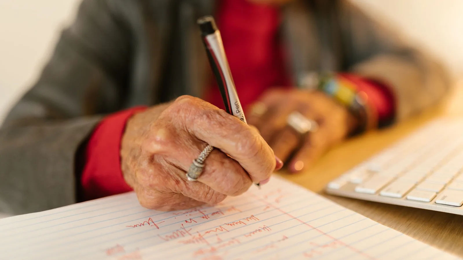 Mano de una persona mayor escribiendo con bolígrafo sobre papel